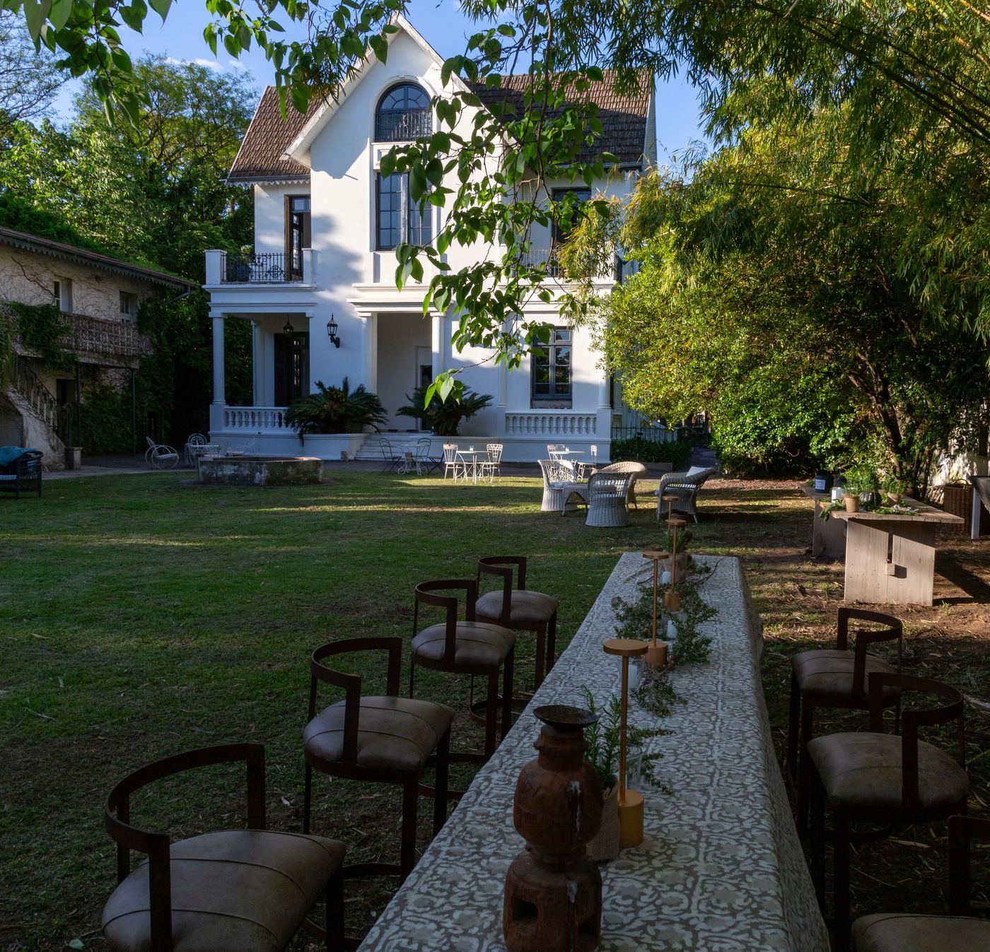 Jardín de Casa Angelman con una mesa larga preparada para un encuentro al aire libre